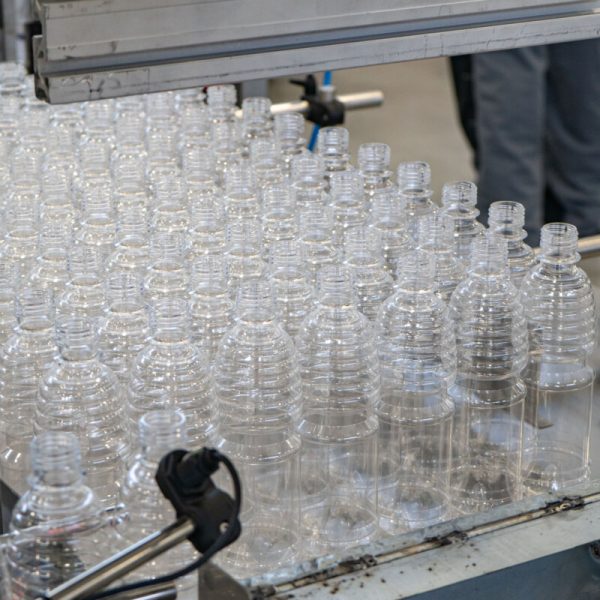 The various type of plastic bottle product and preform material with injection mold background. Drinking container manufacturing processing. High quality photo